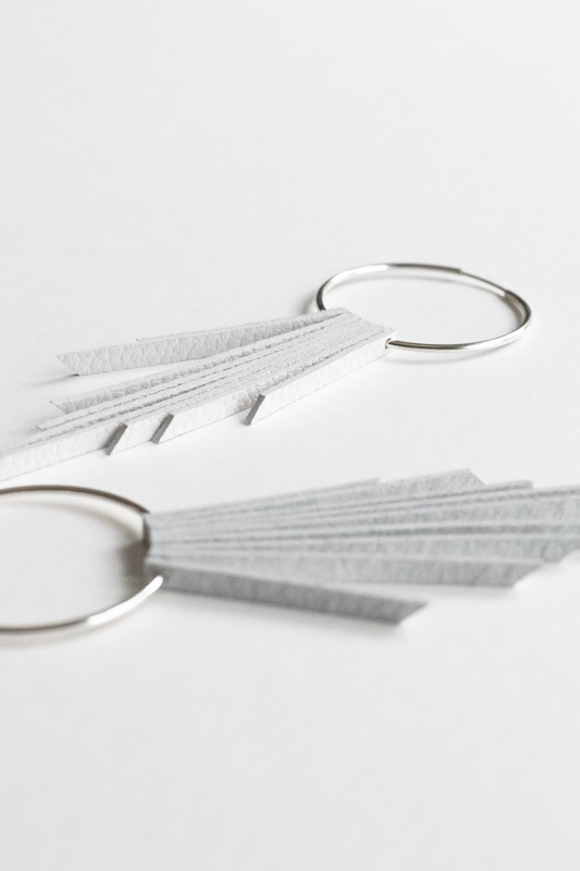 White leather fringe bridal earrings with sterling silver hoops resting on a white backdrop